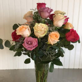 Mixed roses in a clear glass vase with greenery