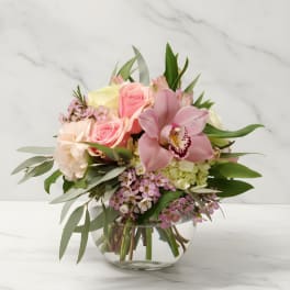 Pink and cream floral bouquet in a clear glass vase