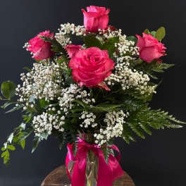 Pink roses with white baby's breath in a glass vase