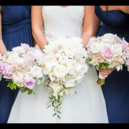 Bride and bridesmaids holding white and pink rose bouquets