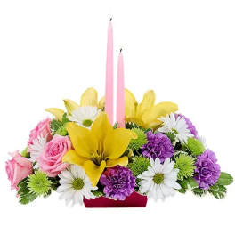 Pink and yellow floral centerpiece with two pink candles