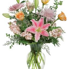 Mixed bouquet with pink lilies, roses, and chrysanthemums in a glass vase