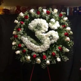 Large funeral wreath with white and red roses on a stand