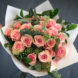 Bouquet of pink roses wrapped in white paper