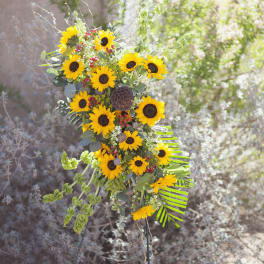 Tall sunflower arrangement with mixed greenery and red berry accents