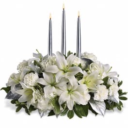 White floral centerpiece with three silver taper candles