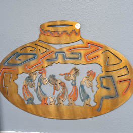 Decorative metal wall art with stylized figures in an oval frame