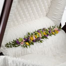 Floral garland on a white chair with pink, purple, and yellow blooms