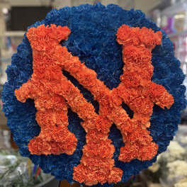 Blue and orange floral tribute with two figures on a round base