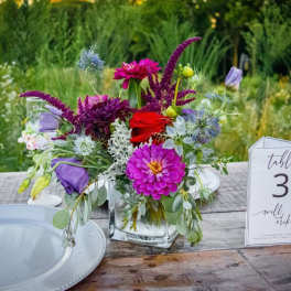 Colorful floral centerpiece in a clear glass vase on a table
