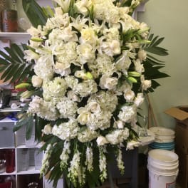 Large white funeral spray with lilies, roses, and hydrangeas