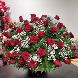 Large bouquet of red roses with white baby's breath in a basket