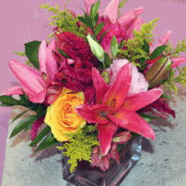 Pink lilies and a yellow rose in a glass vase