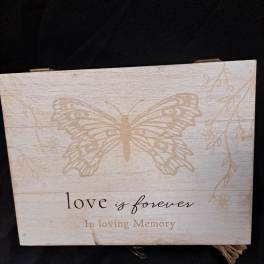 Wooden memorial sign with a butterfly and the words "love is forever"