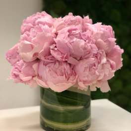 Pink peonies arranged in a green glass vase