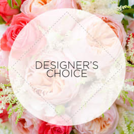 Pink and peach roses with white filler flowers and a designer's choice label