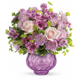 Pink and purple mixed bouquet in a purple glass vase