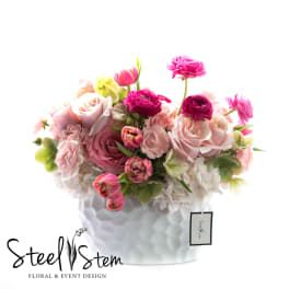 Pink and blush floral arrangement in a white textured vase