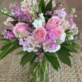 Pink roses and mixed pink-white flowers in a glass vase