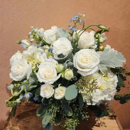 White rose bouquet with pale blue accents and greenery