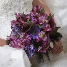 Bride holding a purple and pink bouquet with dark calla lilies