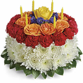 Tiered floral cake with candles in red, orange, white, and yellow flowers