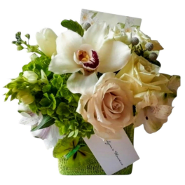 White orchid and cream rose arrangement in a green basket