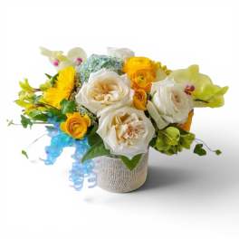 Bouquet of white and yellow flowers in a burlap-wrapped container