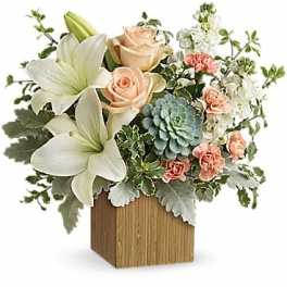 Bouquet of white lilies, peach roses, and pink carnations in a wooden cube vase