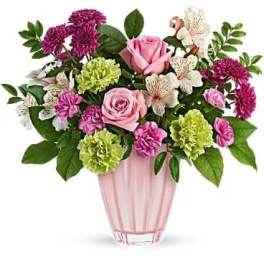 Pink roses and mixed blooms arranged in a pink vase