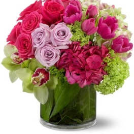 Pink and lavender roses with tulips in a glass vase