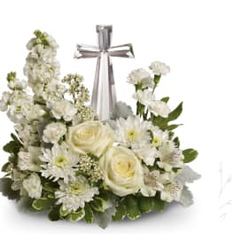 White floral arrangement with a silver cross centerpiece