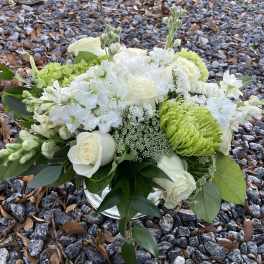 White and green floral arrangement in a glass vase