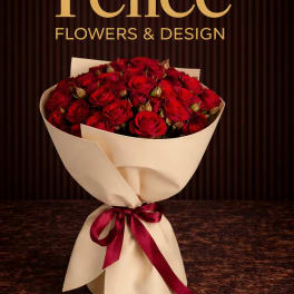 Bouquet of red roses wrapped in cream paper with a burgundy ribbon