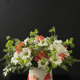 White daisies and pink carnations in a mushroom-decorated ceramic pot