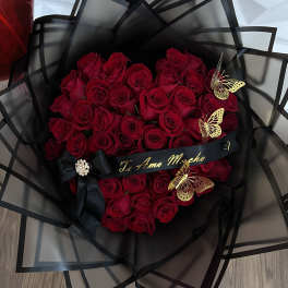 Bouquet of red roses wrapped in black paper with butterfly accents