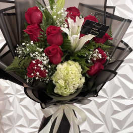 Bouquet of red roses and white lilies with a pale hydrangea bloom