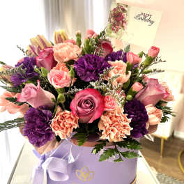 Pink and purple mixed bouquet in a lavender gift box with a birthday card