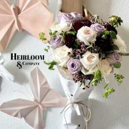 Bouquet of white and lavender roses with dark burgundy accents