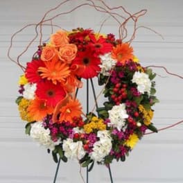 Heart-shaped floral wreath with orange, red, white, and yellow blooms