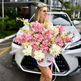 Large pink and white bouquet held in front of a white car