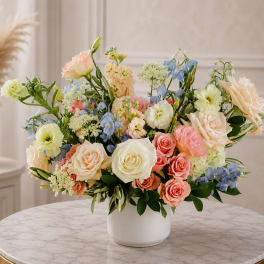 Pastel mixed flower arrangement in a white vase