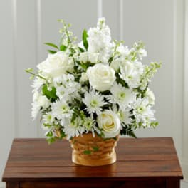 White roses and daisies arranged in a woven basket