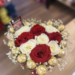 Red and white roses arranged with gold-wrapped chocolates