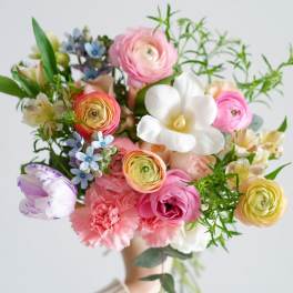 Handheld bouquet of pink, white, and pastel mixed flowers