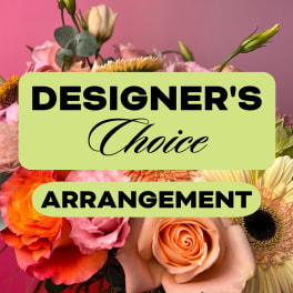 Mixed bouquet with roses, gerbera daisies, and other blooms against a pink background