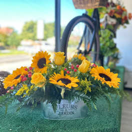 Sunflower and yellow rose arrangement in a metal container