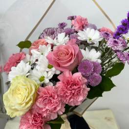 Bouquet of pink and white flowers with purple accents in clear wrap