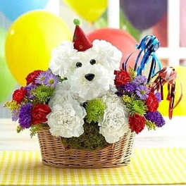 White teddy bear in a basket surrounded by colorful flowers and balloons