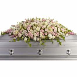 Pink and white rose casket spray with trailing greenery
